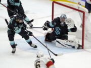 Seattle Kraken goaltender Philipp Grubauer (31) looks on as Kraken center Calle Jarnkrok (19) clears the puck during the second period of an NHL hockey game against the Florida Panthers, Sunday, Jan. 23, 2022, in Seattle. (AP Photo/Ted S.