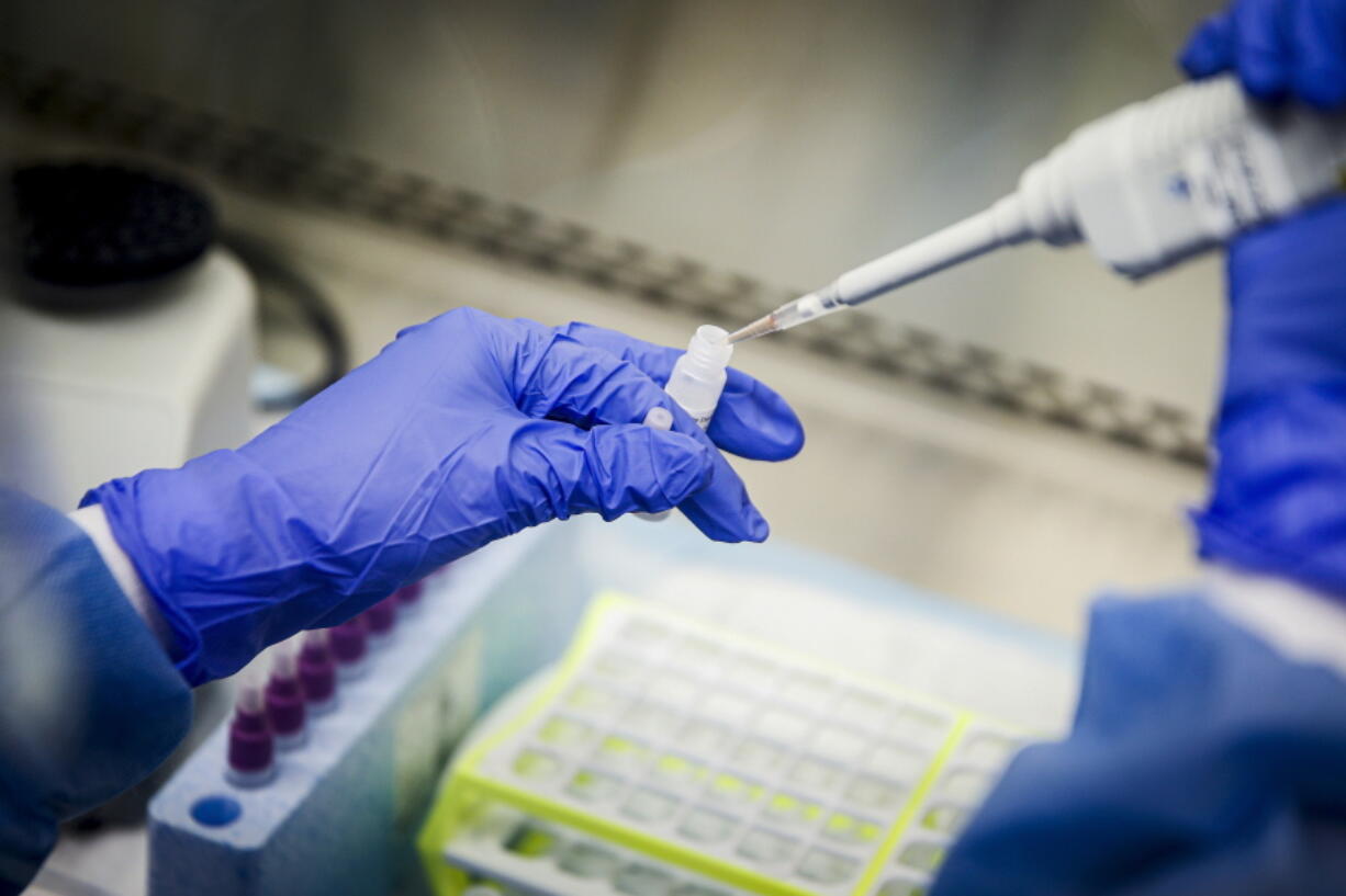 FILE - A laboratory technician prepares COVID-19 patient samples for semi-automatic testing at Northwell Health Labs, March 11, 2020, in Lake Success, N.Y. Republicans' faith in science is falling as Democrats rely on it even more with a trust gap in science and medicine widening substantially during the COVID-19 pandemic, new survey data shows. It's the largest gap in nearly five decades of polling by the General Social Survey, a widely respected trend survey conducted by NORC at the University of Chicago that has been measuring confidence in institutions since 1972.