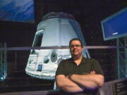 Kyle Hippchen, a Florida-based airline captain, poses for a photo in front of a SpaceX Dragon capsule at the Kennedy Space Center Visitor Complex in Cape Canaveral, Fla., Friday, Jan. 21, 2022. Hippchen, the real winner of a first-of-its-kind sweepstakes, gave his seat on a SpaceX flight to his college roommate. Though his secret is finally out, that doesn't make it any easier knowing he missed his chance to orbit Earth because he exceeded the weight limit.