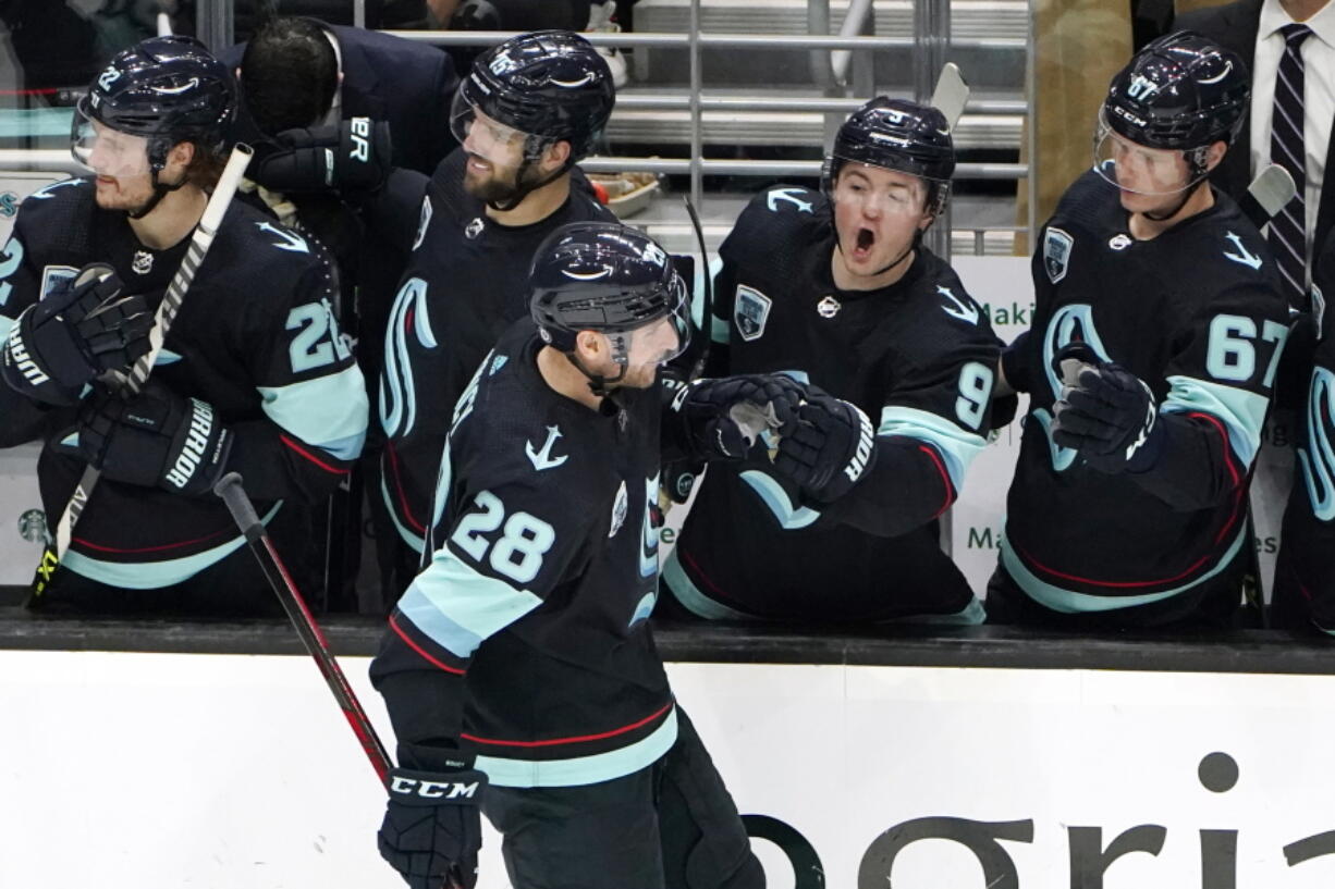 Seattle Kraken's Ryan Donato (9) yells as he congratulates Carson Soucy (28) for scoring against the San Jose Sharks in the second period of an NHL hockey game Thursday, Jan. 20, 2022, in Seattle.