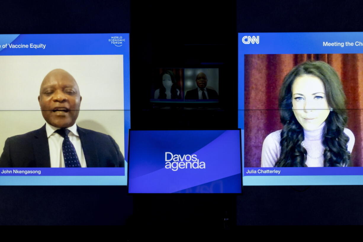 Screens show John Nkengasong, left, Director of the Africa Centres for Disease Control and Prevention (Africa CDC), and Moderator Julia Chatterley, right, during a remotely panel titled "The Challenge of Vaccine Equity", at the Davos Agenda 2022, in Cologny near Geneva, Switzerland, Tuesday, Jan. 18, 2022. The Davos Agenda, from 17 to 21 January 2022, is an online edition due to the coronavirus disease (COVID-19) outbreak gather global leaders to shape the principles, policies and partnerships needed in this challenging context.