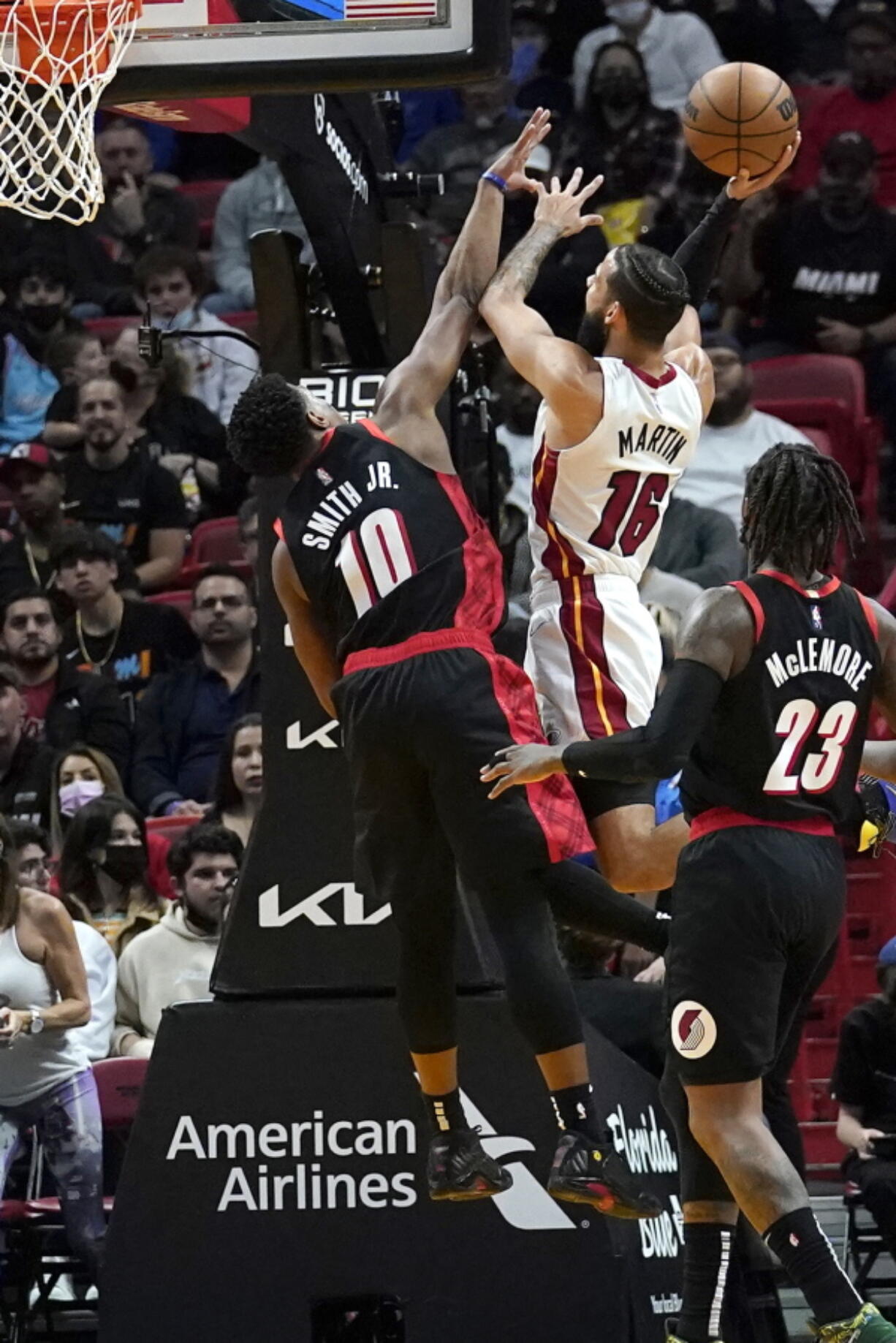 Miami Heat forward Caleb Martin (16) goes to the basket as Portland Trail Blazers guard Dennis Smith Jr. (10) defends during the first half of an NBA basketball game, Wednesday, Jan. 19, 2022, in Miami.