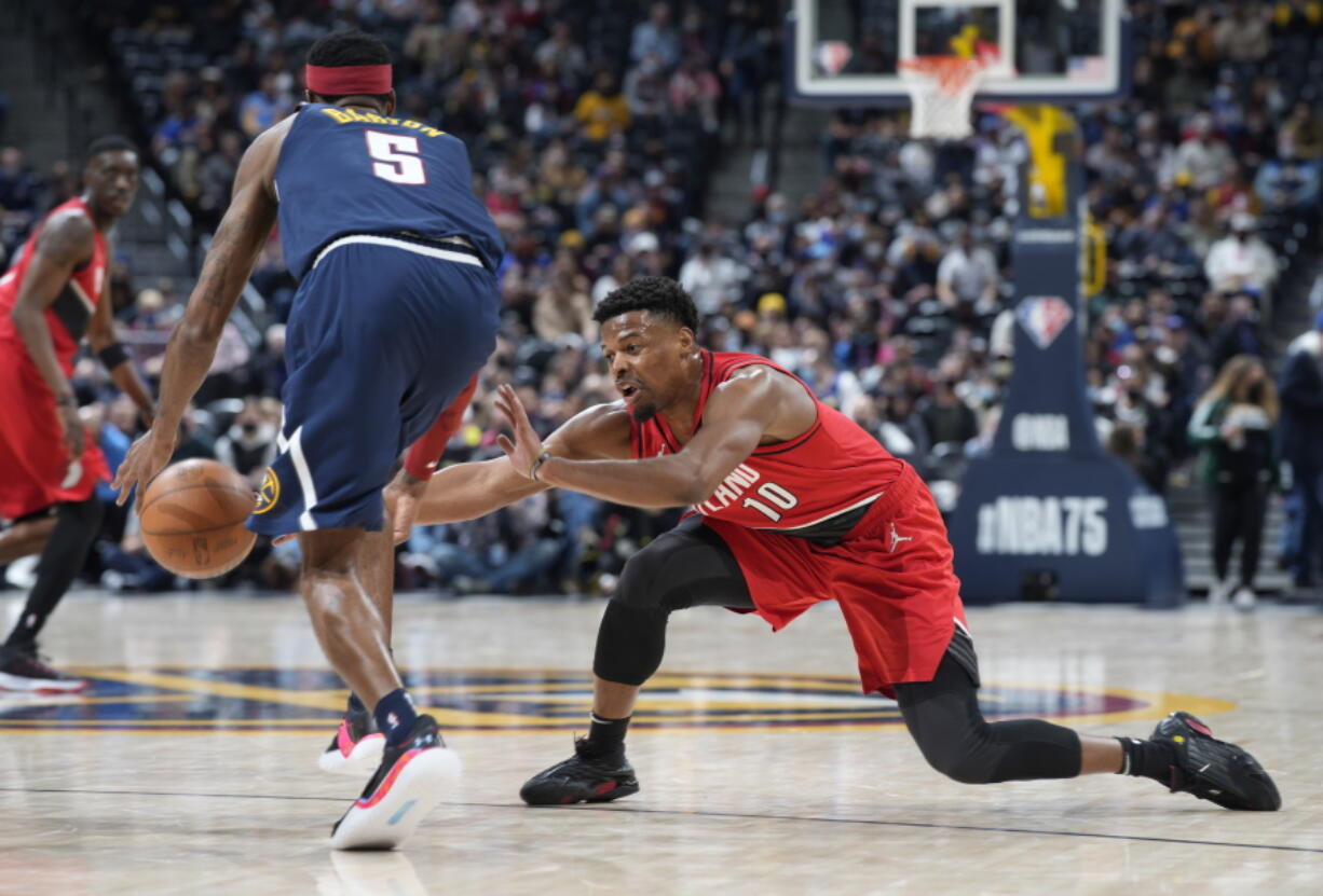 Portland Trail Blazers guard Dennis Smith Jr., right, tries to steal the ball from Denver Nuggets forward Will Barton in the first half of an NBA basketball game Thursday, Jan. 13, 2022, in Denver.