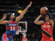 Portland Trail Blazers' Anfernee Simons (1) shoots as Washington Wizards' Spencer Dinwiddie (26) defends during the second half of an NBA basketball game, Saturday, Jan. 15, 2022, in Washington. (AP Photo/Luis M.