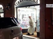 In this image from video made available by Javier Martinez Brocal of Rome Reports, Pope Francis leaves a record shop in Rome, Tuesday, Jan. 11, 2022. Pope Francis grew up listening to the opera on the radio, is a fan of tango and milonga and thinks Mozart "lifts you to God." But it still came as a something of a shock to see him coming out of a downtown Rome record shop Tuesday evening with a CD in hand, after making an unannounced visit that was caught on camera by a Vatican reporter who happened to be nearby.