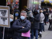 FILE - People wait in line at a COVID-19 testing site in Times Square, New York, Monday, Dec. 13, 2021. Scientists are warning that omicron's lightning-fast spread across the globe practically ensures it won't be the last worrisome coronavirus variant. And there's no guarantee the next ones will cause milder illness or that vaccines will work against them.