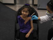 FILE - Elsa Estrada, 6, smiles at her mother as pharmacist Sylvia Uong applies an alcohol swab to her arm before administering the Pfizer COVID-19 vaccine at a pediatric vaccine clinic for children ages 5 to 11 set up at Willard Intermediate School in Santa Ana, Calif., Nov. 9, 2021. As of Tuesday, Jan. 11, 2022, just over 17% of children in the U.S. ages 5 to 11 were fully vaccinated, more than two months after shots for them became available. (AP Photo/Jae C.