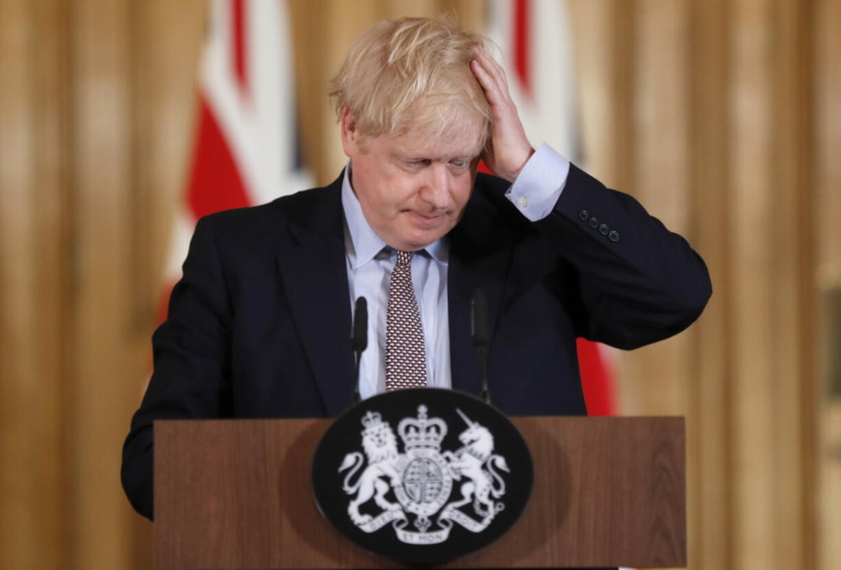 FILE - Britain's Prime Minister Boris Johnson reacts during a press conference at Downing Street on the government's coronavirus action plan in London Tuesday, March 3, 2020.