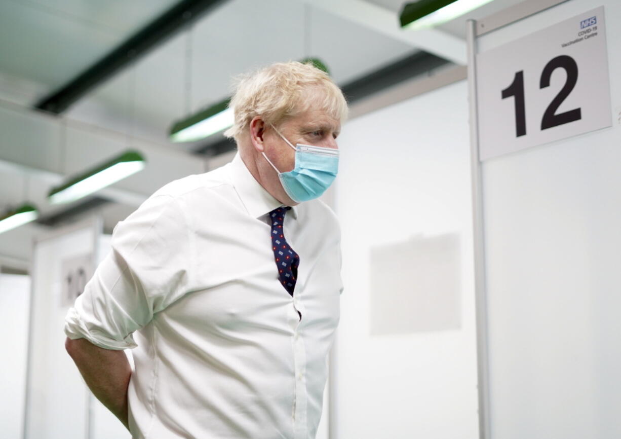 Britain's Prime Minister Boris Johnson visits a vaccination hub in the at Stoke Mandeville Stadium in Aylesbury, England, Monday Jan. 3, 2022, as the booster vaccination programme continues.