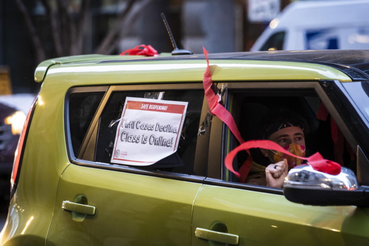 FILE - Members of the Chicago Teachers Union and supporters stage a car caravan protest outside City Hall in the Loop, Jan. 5, 2022. Talks between Chicago school leaders and the teachers union resumed Sunday, Jan. 9, 2022 amid a standoff over remote learning and other COVID-19 safety measures. The situation looms over the start of a second week of school after three days of canceled classes in the nation's third-largest district.