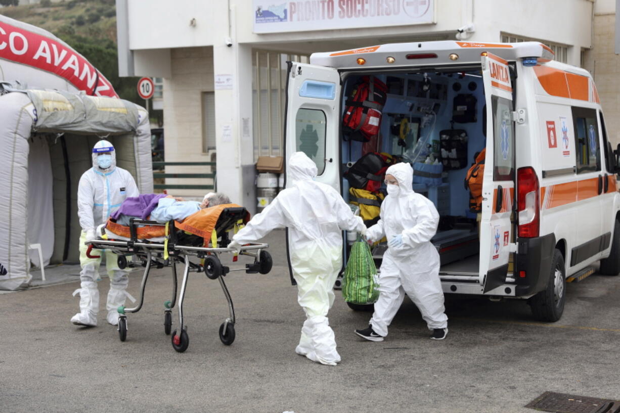 An ambulance for covid emergency unload a patient at the Cervello hospital in Palermo, Sicily, where tented field hospitals have been set up in front of three hospitals to relieve the pressure on the emergency room and allow ambulances to get their patients into a bed rather than wait in line in the parking lot, Friday, Jan. 7, 2022. Sicily has seen its caseload double in recent days, from around 6,000 a day to 14,000 on Thursday, and has just under 1,000 people hospitalized with the virus.