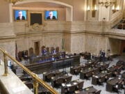 FILE - House Republican Leader J.T. Wilcox, R-Yelm, is displayed on video screens as he speaks remotely following opening remarks from House Speaker Laurie Jinkins, D-Tacoma, during the opening session of the Washington state House, Jan. 10, 2022, at the Capitol in Olympia, Wash. As lawmakers in some Democratic-led states meet remotely because of renewed COVID-19 concerns, their counterparts in many Republican-led legislatures are beginning their 2022 sessions with an aggressive push to outlaw vaccine requirements in workplaces and schools and roll back the government's power to mandate pandemic precautions. (AP Photo/Ted S.