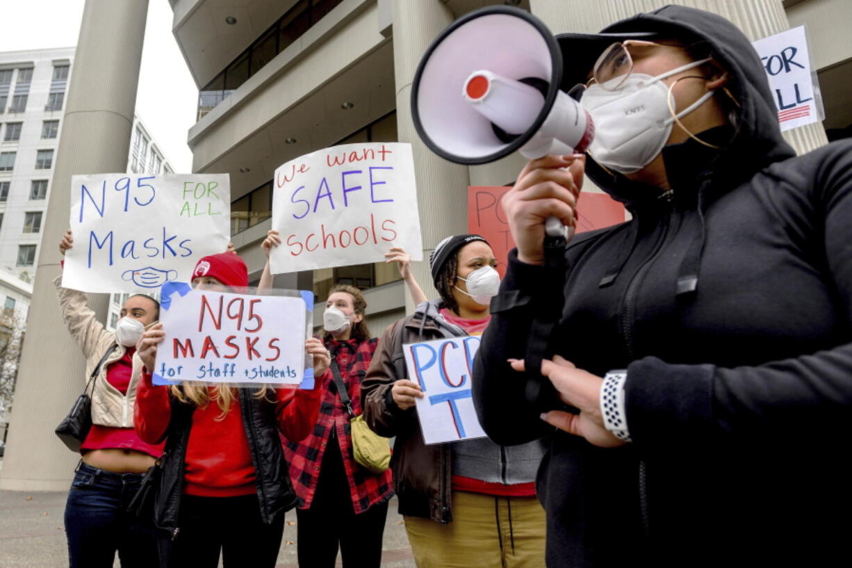 FILE - Teachers protest for stronger COVID-19 safety protocols outside Oakland Unified School District headquarters on Jan. 7, 2022, in Oakland, Calif. Officials across the U.S. are again weighing how and whether to impose mask mandates as COVID-19 infections soar and the American public grows weary of pandemic-related restrictions. Much of the debate centers around the nation's schools, some of which closed due to infection-related staffing issues.