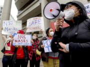 FILE - Teachers protest for stronger COVID-19 safety protocols outside Oakland Unified School District headquarters on Jan. 7, 2022, in Oakland, Calif. Officials across the U.S. are again weighing how and whether to impose mask mandates as COVID-19 infections soar and the American public grows weary of pandemic-related restrictions. Much of the debate centers around the nation's schools, some of which closed due to infection-related staffing issues.