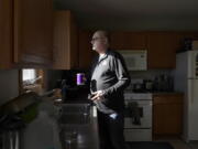 Roger Strukhoff 67, looks out his kitchen window after making a cup of coffee Thursday in his DeKalb, Ill., home. Strukhoff was being treated for intestinal bleeding at a hospital outside Chicago this month when he suffered a mild heart attack.