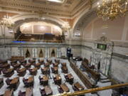 A lone worker walks on the floor of the Washington Senate, Thursday, Jan. 6, 2022, at the Capitol in Olympia. (AP Photo/Ted S.