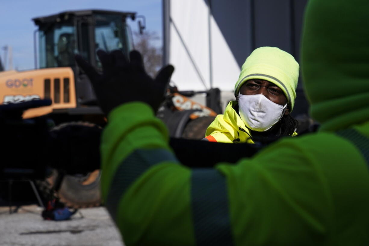 A Georgia Department of Transportation response member looks at a brine truck tank being filled ahead of a winter storm at the GDOT's Maintenance Activities Unit location on Friday, Jan. 14, 2022, in Forest Park, Ga. A winter storm is headed south that could effect much of Georgia through Sunday.