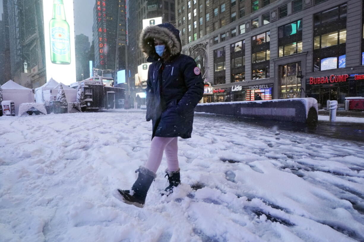 A girls kicks at snow n New York's Times Square, Friday, Jan. 7, 2022.  A winter storm that has already left areas of the south with more than 6 inches of snow moved into the northeast during the morning commute and prompted many school districts to close for the day.