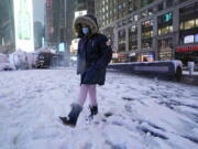 A girls kicks at snow n New York's Times Square, Friday, Jan. 7, 2022.  A winter storm that has already left areas of the south with more than 6 inches of snow moved into the northeast during the morning commute and prompted many school districts to close for the day.