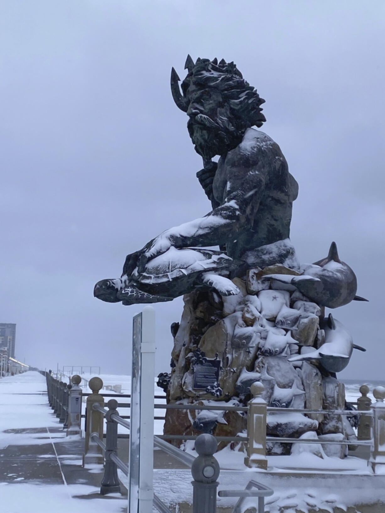 The Virginia Beach oceanfront covered in snow Saturday,  Jan. 22, 2022 in Virginia Beach, Va. A layer of ice and a blanket of snow has covered coastal areas stretching from South Carolina to Virginia. The winter weather system that entered the region on Friday brought colder temperatures and precipitation not often seen in the region.