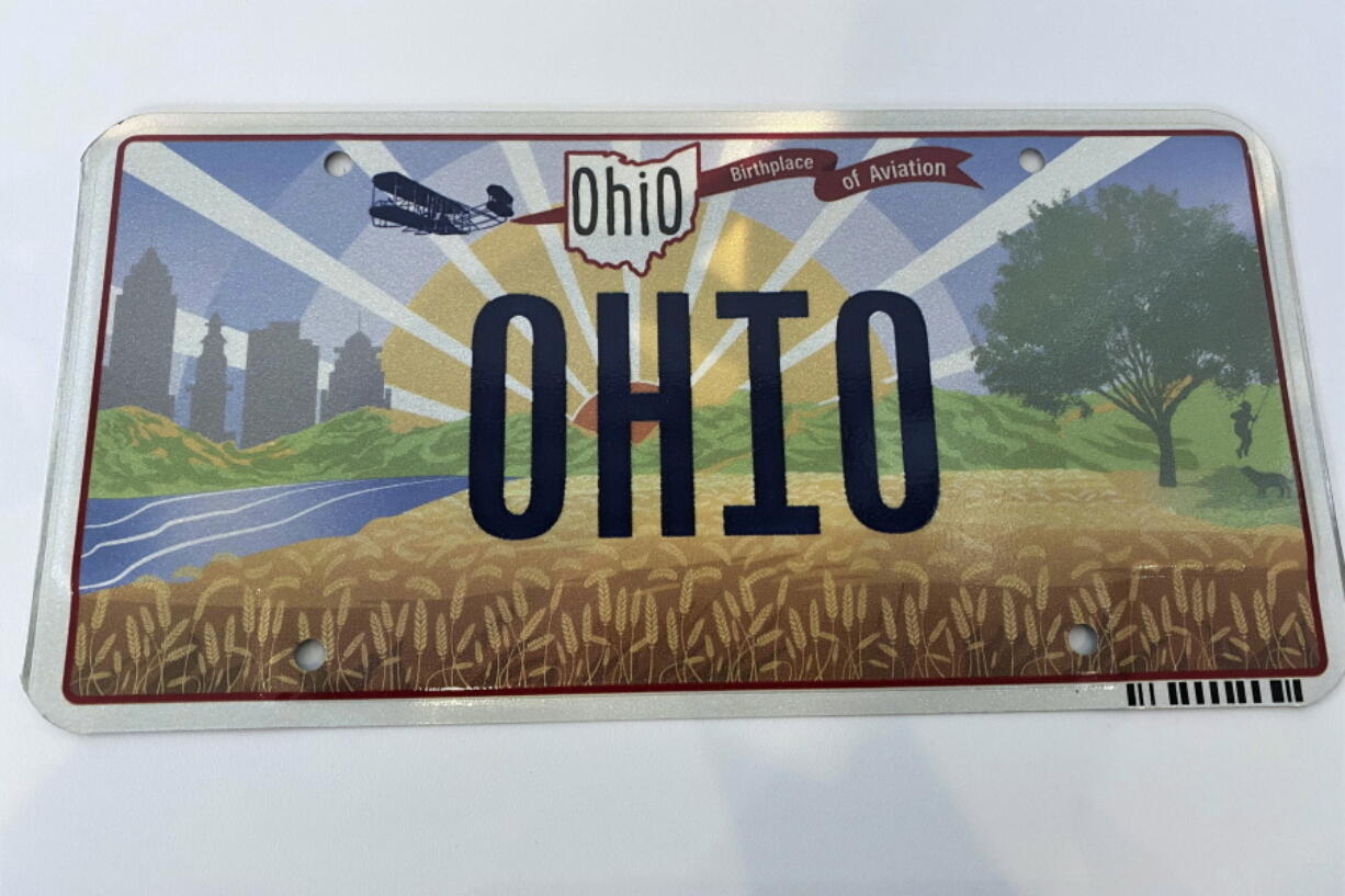 FILE - Ohio Gov. Mike DeWine on Thursday, Oct. 21, 2021, unveiled the new "Sunrise in Ohio" license plate in Columbus, Ohio. A backwards image of the Wright Flyer that appeared on the initial version of Ohio's new license plate was added to the design early and never changed or questioned throughout the approval process, according to public records obtained by The Associated Press. The error was fixed only after the public unveiling in October drew attention to it.