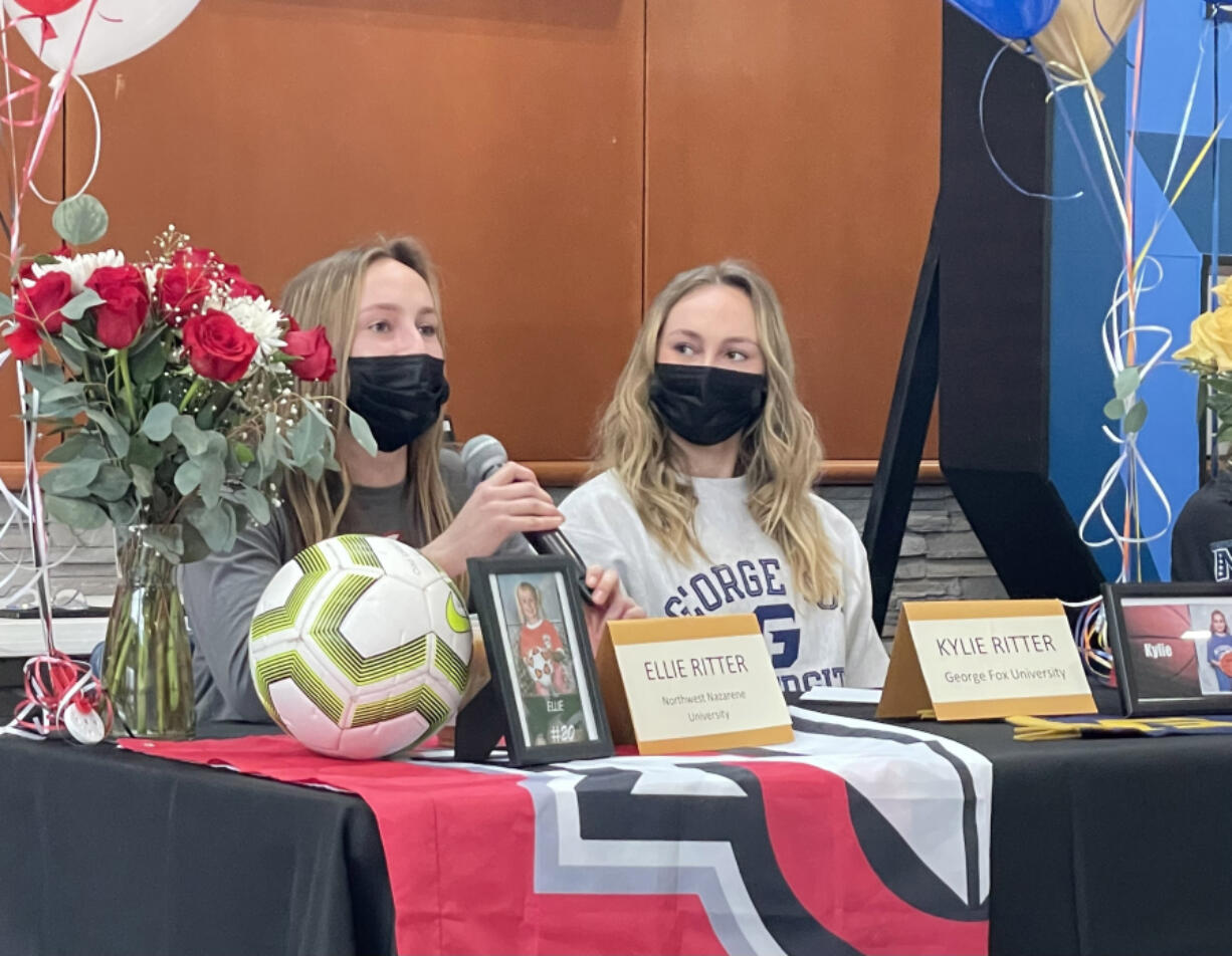 Hockinson senior Ellie Ritter, left, speaks to the crowd at the school?s signing day, while twin sister Kylie Ritter, right, looks on Wednesday at Hockinson High School. Ellie will attend Northwest Nazarene University to play soccer and Kylie is headed to George Fox University to play basketball.