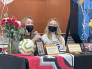 Hockinson senior Ellie Ritter, left, speaks to the crowd at the school?s signing day, while twin sister Kylie Ritter, right, looks on Wednesday at Hockinson High School. Ellie will attend Northwest Nazarene University to play soccer and Kylie is headed to George Fox University to play basketball.