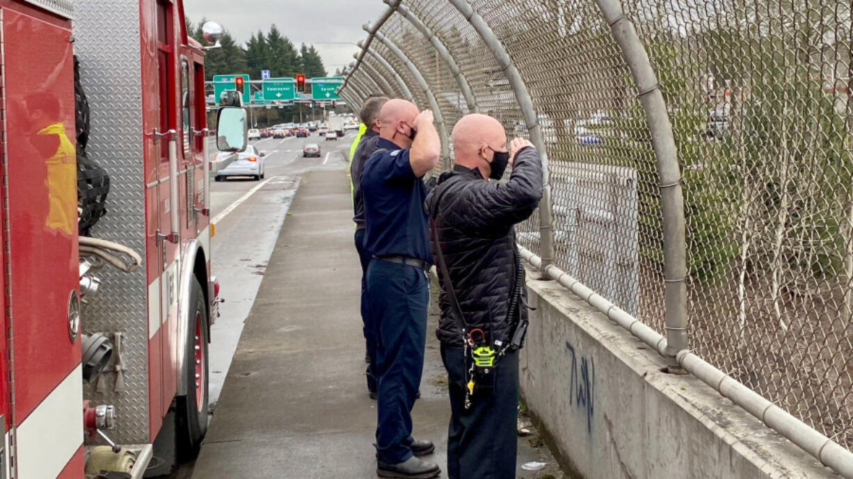 Clark County Fire District 6 personnel pay their respects Thursday to slain Vancouver police Officer Donald Sahota as his body was transported from Vancouver to Battle Ground, along Interstate 5.