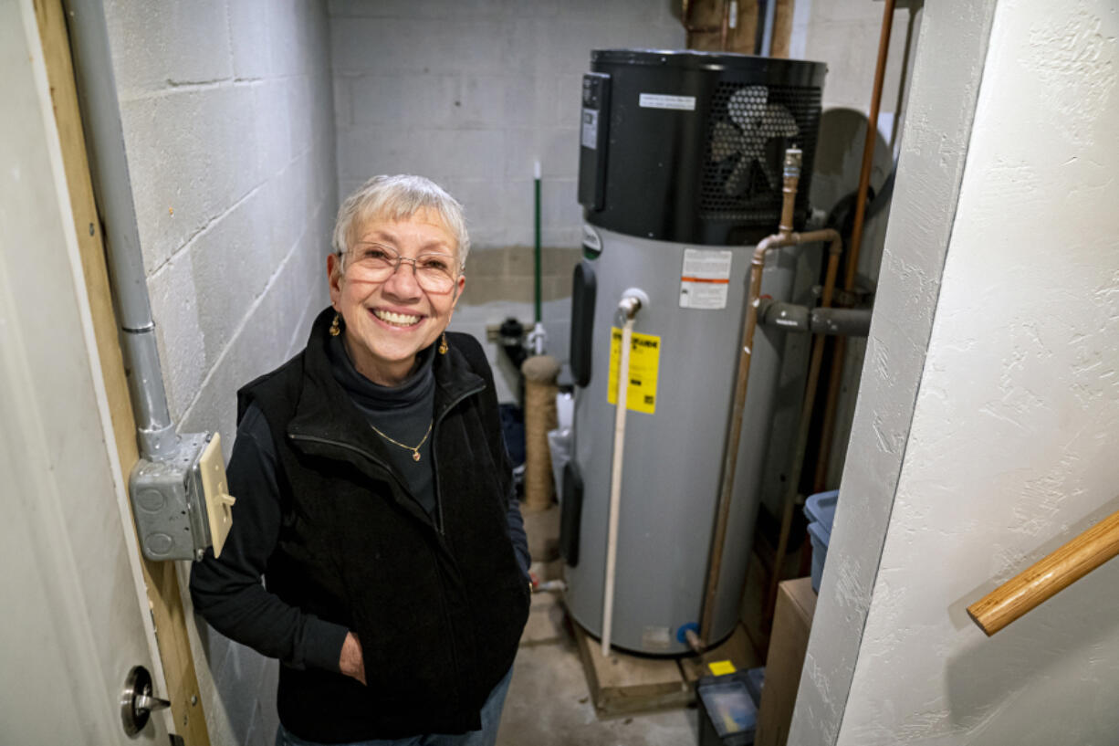 Toni Walker stands next to her heat pump water heater in her home Jan. 18 in Monroeville, Pa.