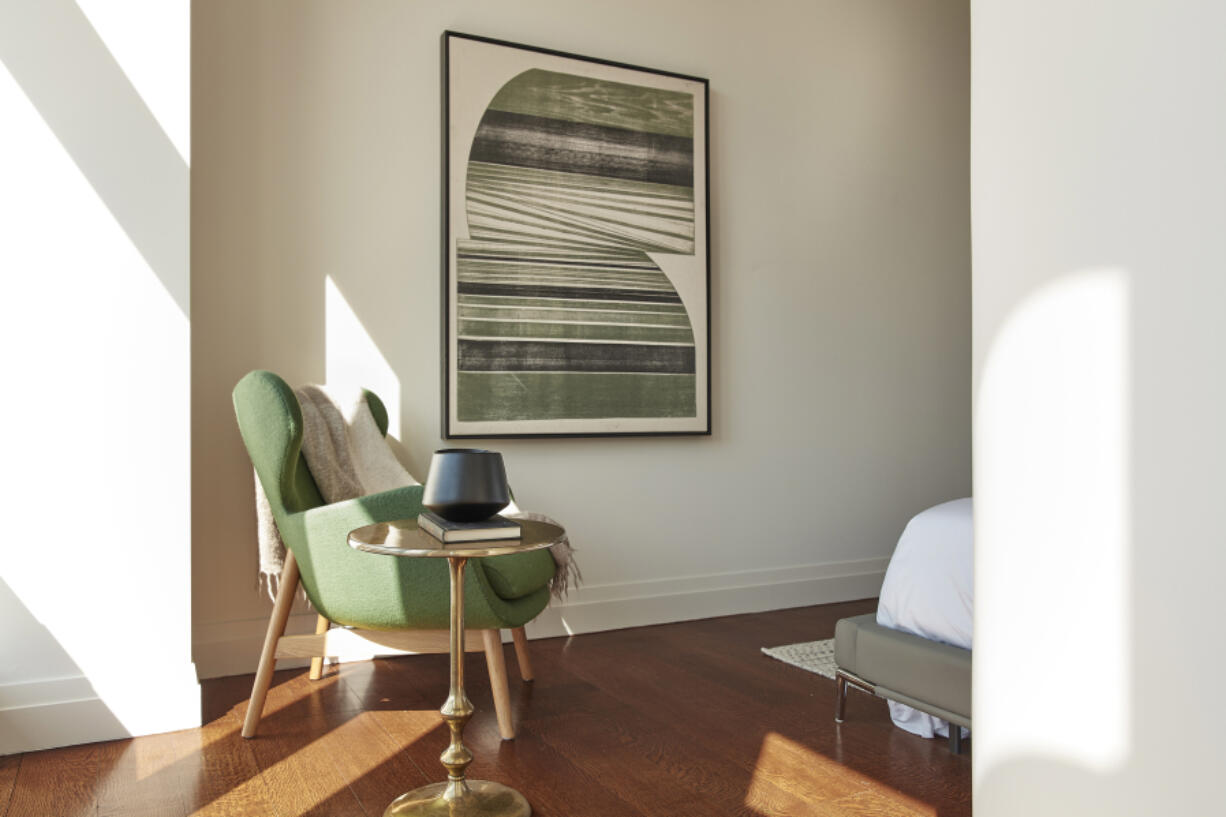 A large piece of art with green as its primary color is paired with a bold green chair.