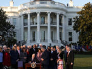 U.S. President Joe Biden signs the Infrastructure Investment and Jobs Act as he is surrounded by lawmakers and members of his Cabinet during a ceremony on the South Lawn at the White House on Nov. 15, 2021, in Washington, D.C.