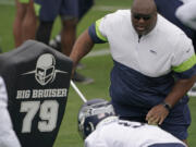 Seattle Seahawks defensive line and assistant head coach Clint Hurtt, right, runs a drill during NFL football practice Tuesday, June 15, 2021, in Renton, Wash. (AP Photo/Ted S.