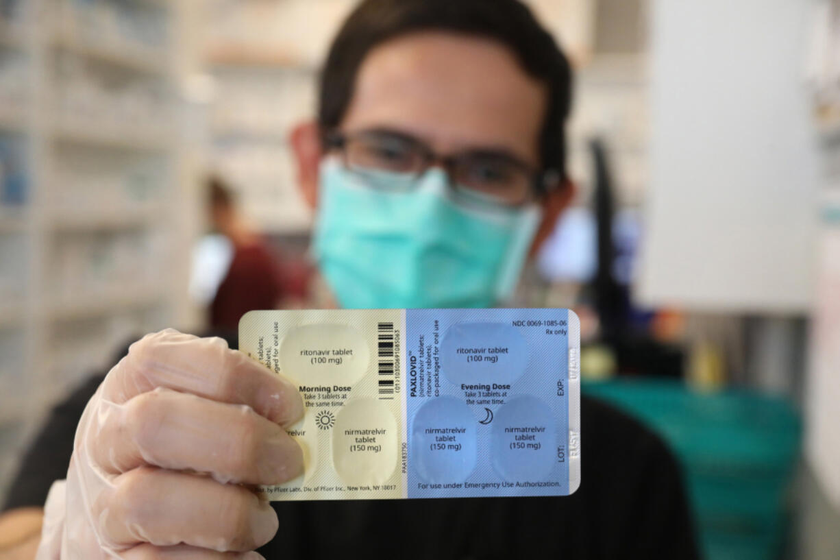 SureCare Pharmacy manager Oscar Uribe shows off a package of Pfizer Paxlovid pills inside of Esperanza Health Center in Chicago's Brighton Park neighborhood on Thursday, Jan. 13, 2022. Pfizer's Paxlovid  is a treatment for COVID-19.