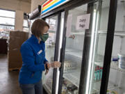 FISH of Vancouver Operations Manager Anina Estrem lends a hand at the organization's facility Tuesday morning as people  line up for food. The organization is running low on juice, yogurt, creamer, fresh produce and more. Volunteers are also in short supply. Local food banks are experiencing a shortage of volunteers and diminished food supply due to the recent surge in COVID-19 cases.