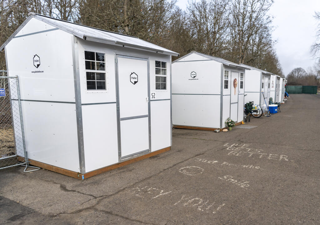 Encouraging messaging sits on the ground outside a row of pallet homes Tuesday, Feb. 8, 2022, at the Stay Safe Community in east Vancouver.