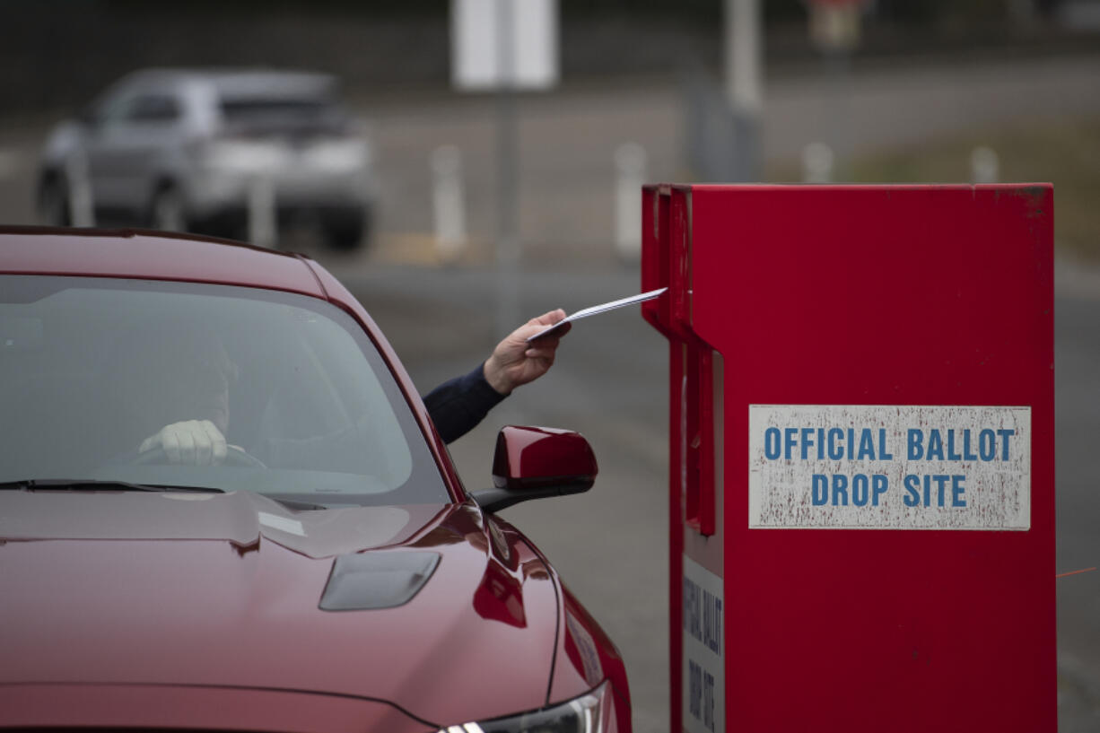 A voter swings by the Fisher's Landing ballot drop-off box on in February 2022.