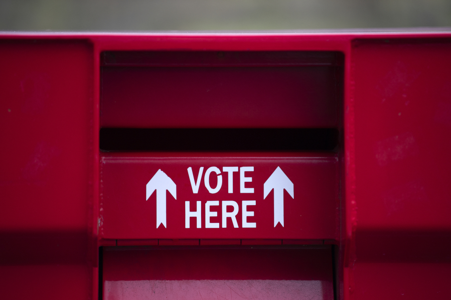 Voters stop by the Fisher's Landing ballot drop-off box Monday.