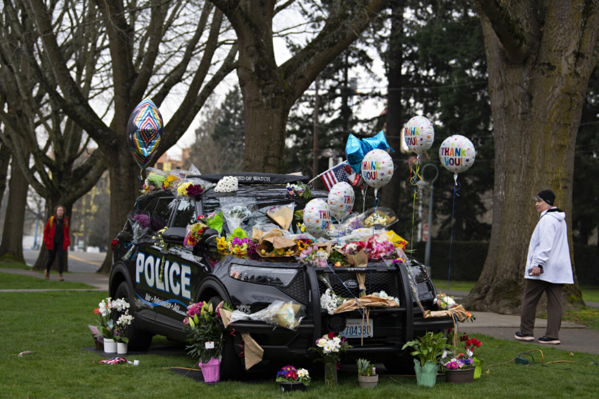 Maggie Williams of Vancouver pauses during her walk to take in the memorial to Officer Donald Sahota on Monday morning outside the Vancouver Police Department headquarters. Sahota's memorial service is scheduled to begin at 1 p.m. Tuesday at ilani casino on the Cowlitz Indian Reservation.