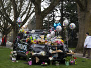 Maggie Williams of Vancouver pauses during her walk to take in the memorial to Officer Donald Sahota on Monday morning outside the Vancouver Police Department headquarters. Sahota's memorial service is scheduled to begin at 1 p.m. Tuesday at ilani casino on the Cowlitz Indian Reservation.