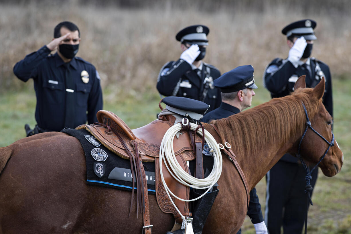 A riderless horse passes an honor guard while taking part in the procession and motorcade honoring Officer Donald Sahota at ilani Casino Resort on Tuesday afternoon, Feb. 8, 2022.