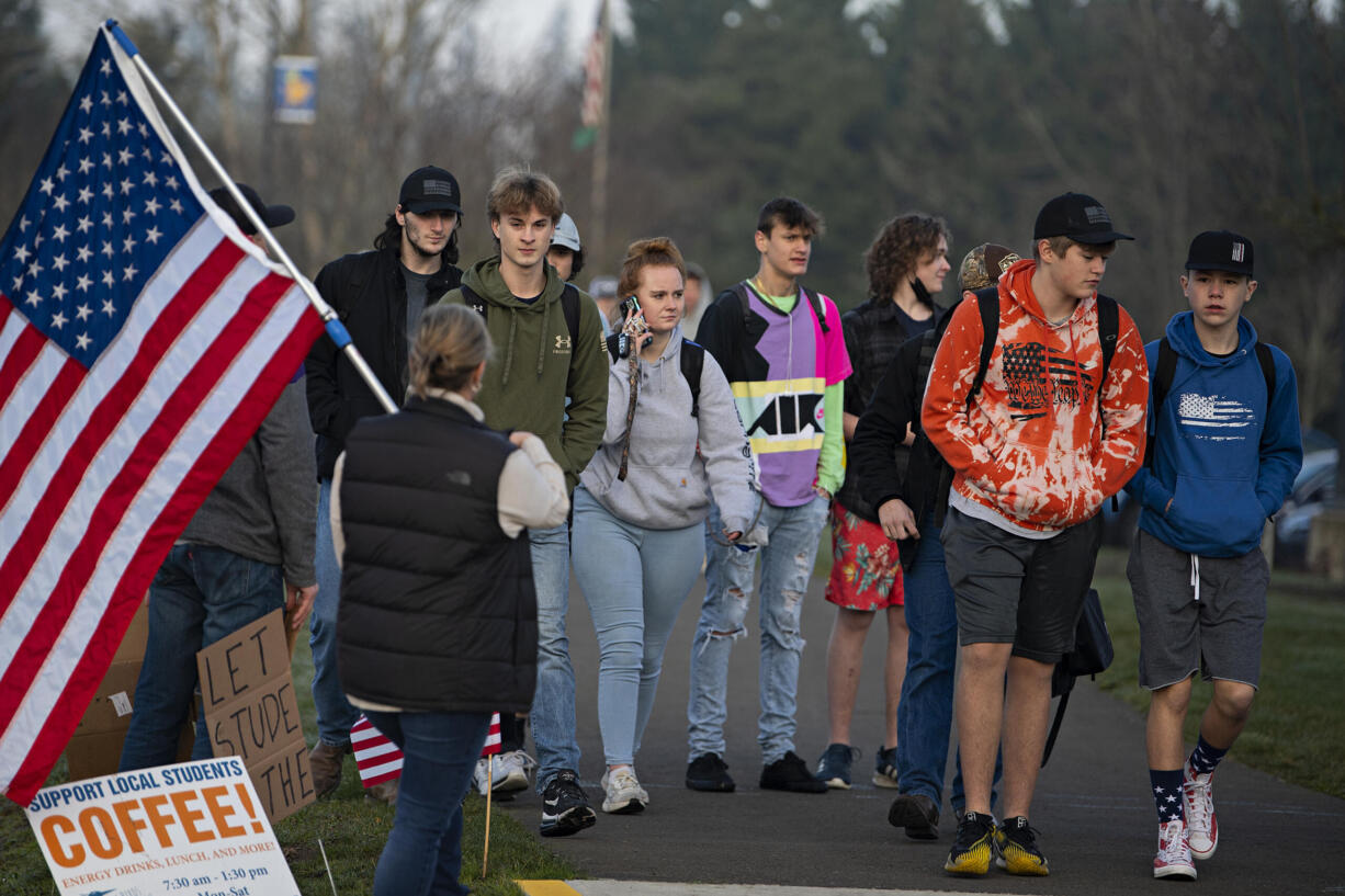 Students join a small group of protesters demonstrating against mandatory masks in schools outside Ridgefield High School on Wednesday morning, Feb. 9, 2022.