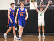 Ridgefield seniors Ty Snider, left, and Joseph Borgmeyer walk off the court while Tumwater senior Adam Overbay celebrates Tuesday, Feb. 15, 2022, after the Spudders' 51-46 loss to Tumwater at Woodland High School.