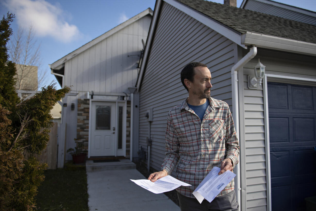 Jon Day holds letters he received from the city of Vancouver outside his Airbnb rental. The city is in the early stages of figuring out its long-term plan and laws for Airbnb and other short-term rental homes. Some homeowners rent their homes for financial support with no objections from neighbors, but other homes are a source of complaints.