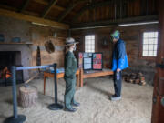 Park Ranger Justine Hanrahan, left, welcomes Jim Stenlund of Vancouver to a reconstructed house at the Fort Vancouver village on Saturday. "Every time I come out here, I learn something new," said Stenlund, who walks at Fort Vancouver daily.