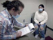 Daniel Salazar, patient care coordinator for the Free Clinic of Southwest Washington, checks in a patient at the clinic located at 4100 Plomondon St.