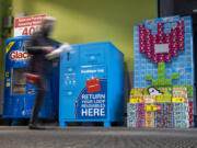 A shopper walks in front of a Loop return bin Tuesday at the Grand Central Fred Meyer. The company is partnering with Loop, which offers reusable packaging for select groceries.