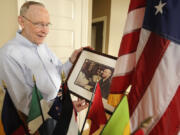 Chief Master Sgt. E.E. "Van" Valkenberg holds a picture of himself on Air Force One as he reflected on his past at his Vancouver home in 2011. Valkenberg was a radio operator in World War II and served in the U.S. Navy toward the end of the war. Soon after, he joined the Air Force where he served in the Korean War, the Cuban missile crisis and the Vietnam War.