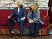 Washington Gov. Jay Inslee holds a copy of his speech as he sits with his wife Trudi before giving his annual State of the State address, Tuesday, Jan. 11, 2022, at the Capitol in Olympia, Wash. Due to cautions against COVID-19, Inslee gave his speech in the State Reception Room and it was shown by streaming video to lawmakers meeting remotely. (AP Photo/Ted S.