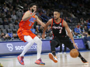 Portland Trail Blazers guard CJ McCollum, right, drives against Oklahoma City Thunder forward Kenrich Williams in the first half of an NBA basketball game Monday, Jan. 31, 2022, in Oklahoma City.