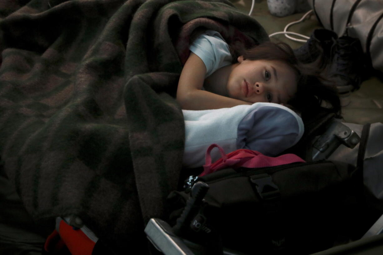 A child from Ukraine sleeps in a tent part of a humanitarian centre for refugees at the Moldovan-Ukrainian border, in Palalanca, Moldova, Friday, Feb. 25, 2022. Thousands of Ukrainians are fleeing from war by crossing their borders to the west in search of safety. They left their country as Russia pounded their capital and other cities with airstrikes for a second day on Friday. Cars were backed up for several kilometers (miles) at some border crossings as authorities in Poland, Slovakia, Hungary, Romania and Moldova mobilized to receive them, offering them shelter, food and legal help.